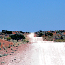 Straße durch die Kalahari Wüste in Namibia - Sonnenwetter soweit das Auge reicht